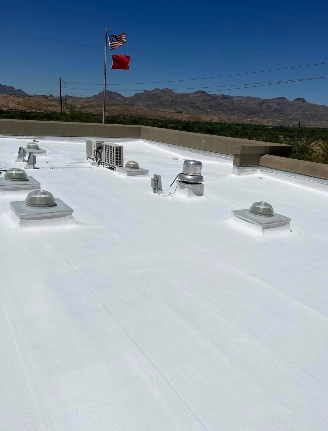 Completed Rio Rico fire station roof coating project by W&D Roofing with reflective white coating and mountain views