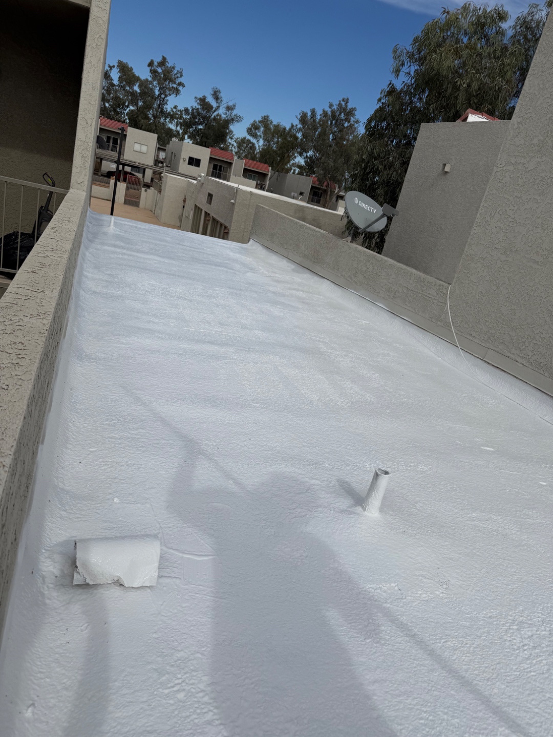 Completed W&D Roofing flat roof coating project with reflective white roof surface