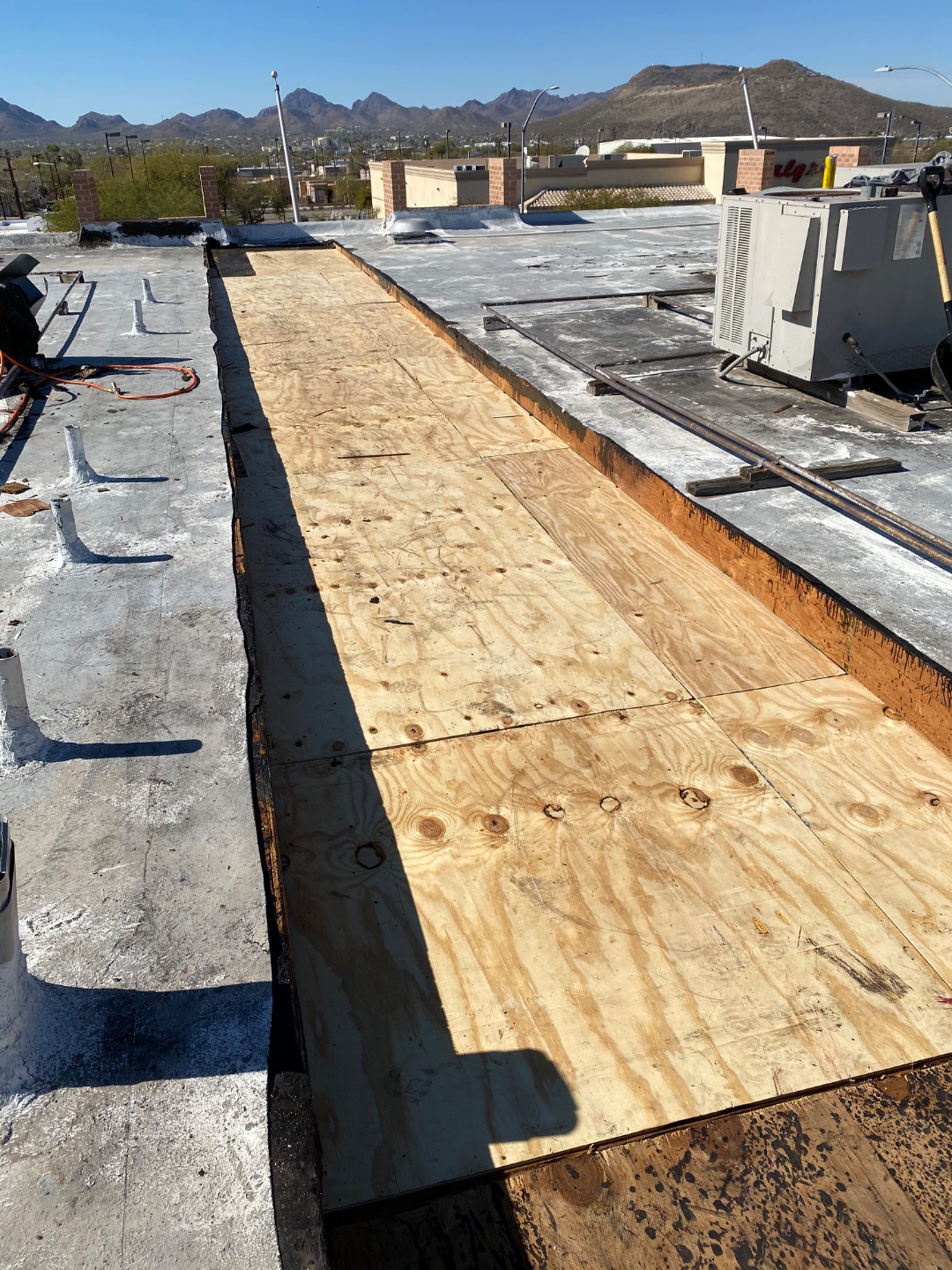 Commercial roof progress photo showing new plywood decking installed by W&D Roofing